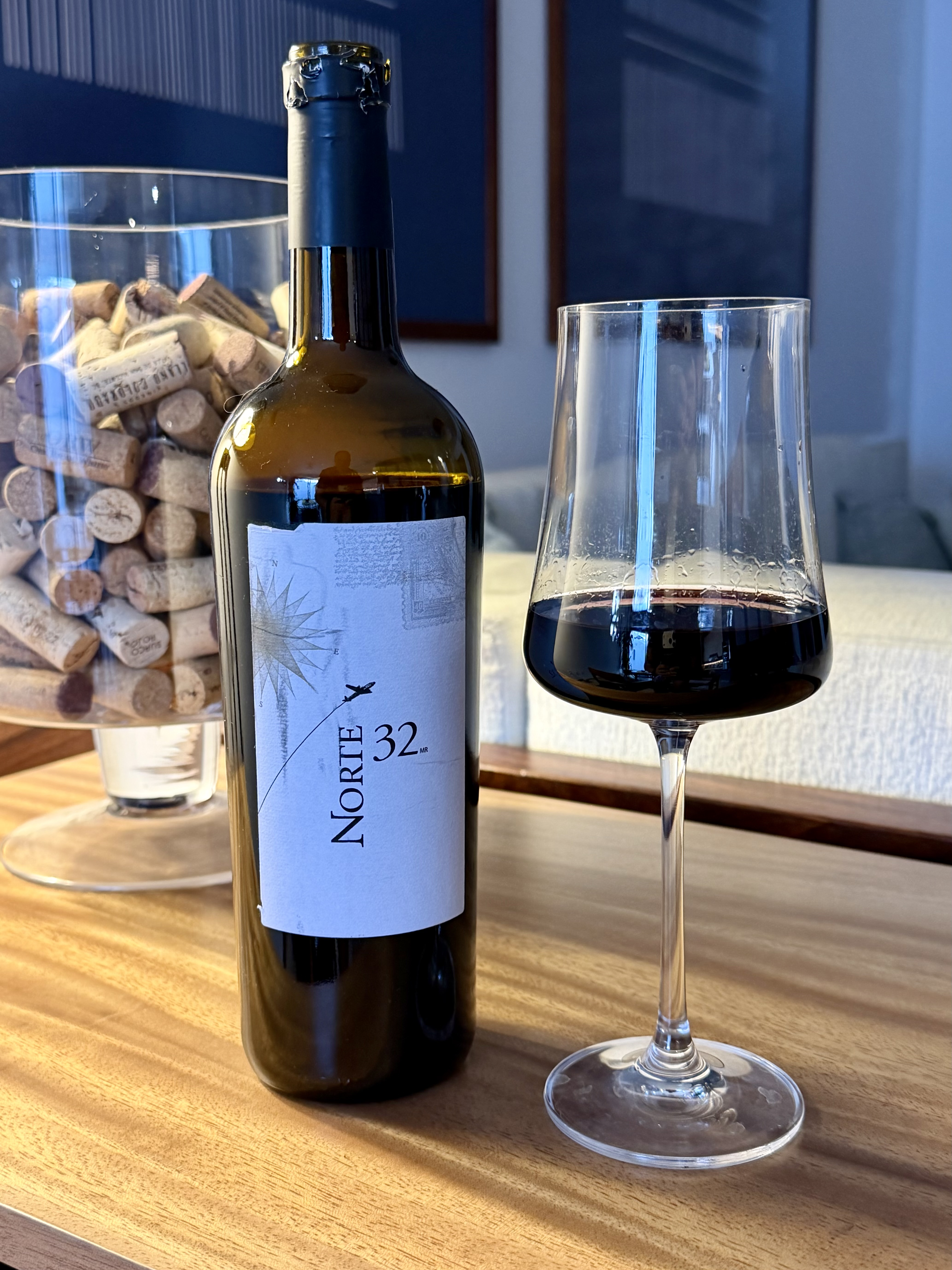 Botella de vino mexicano Norte 32 junto a una copa de vino tinto