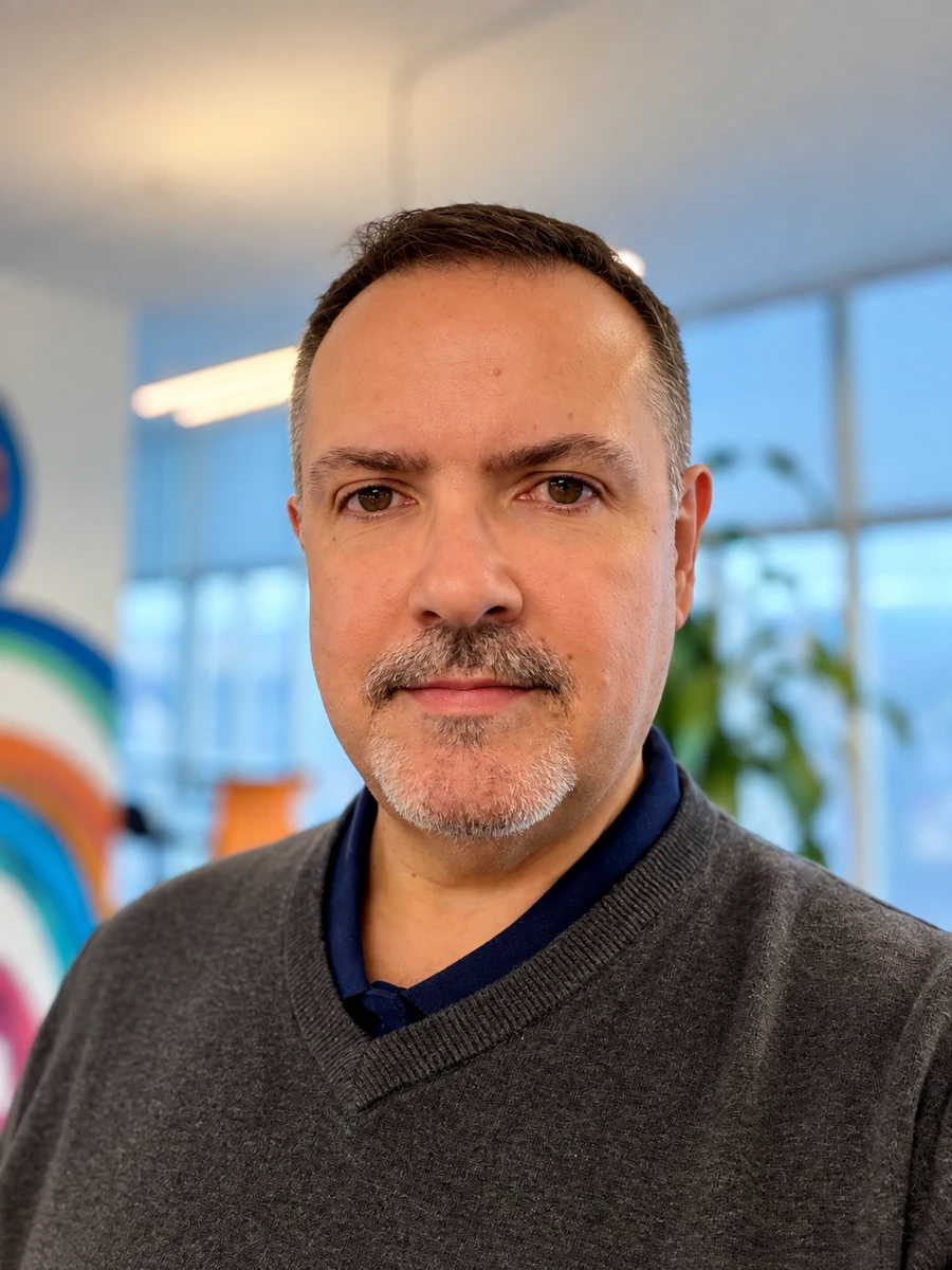Retrato de Sergio Morilo con suéter gris en una oficina